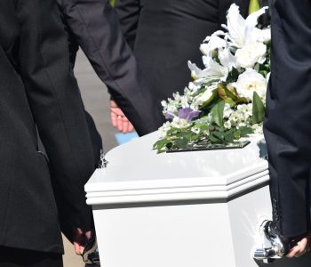 Personnes portant un cercueil blanc