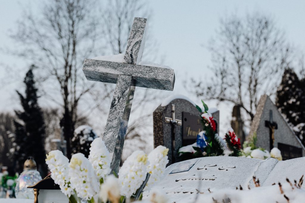 Un lieu d'inhumation avec des fleurs blanches et une croix
